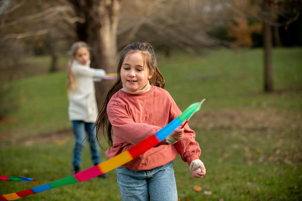 girl playing on park with ribbons